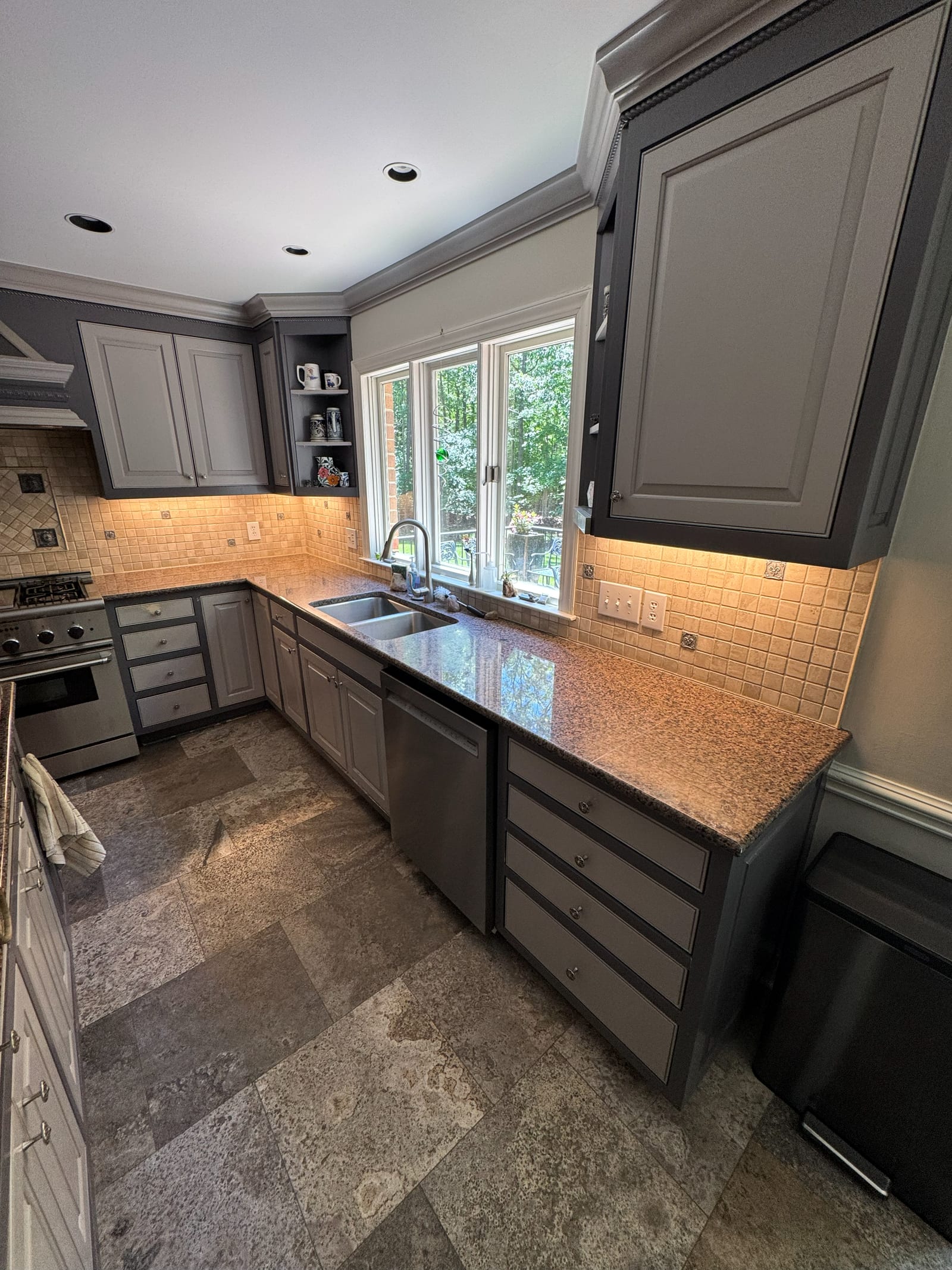 Kitchen with under-cabinet lighting lit along the counter and recessed ceiling lights above
